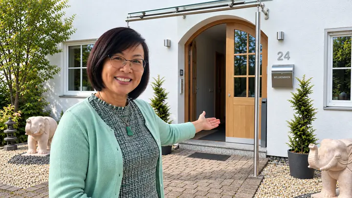 Theresa Poll zve dovnitř a ukazuje na otevřené vchodové dveře Casa Theresa